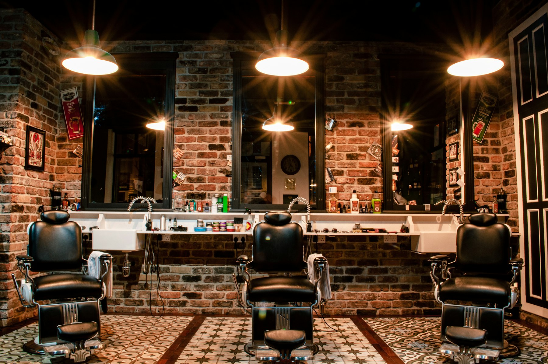 The shop: three vintage chairs under warm lamps against a brick wall